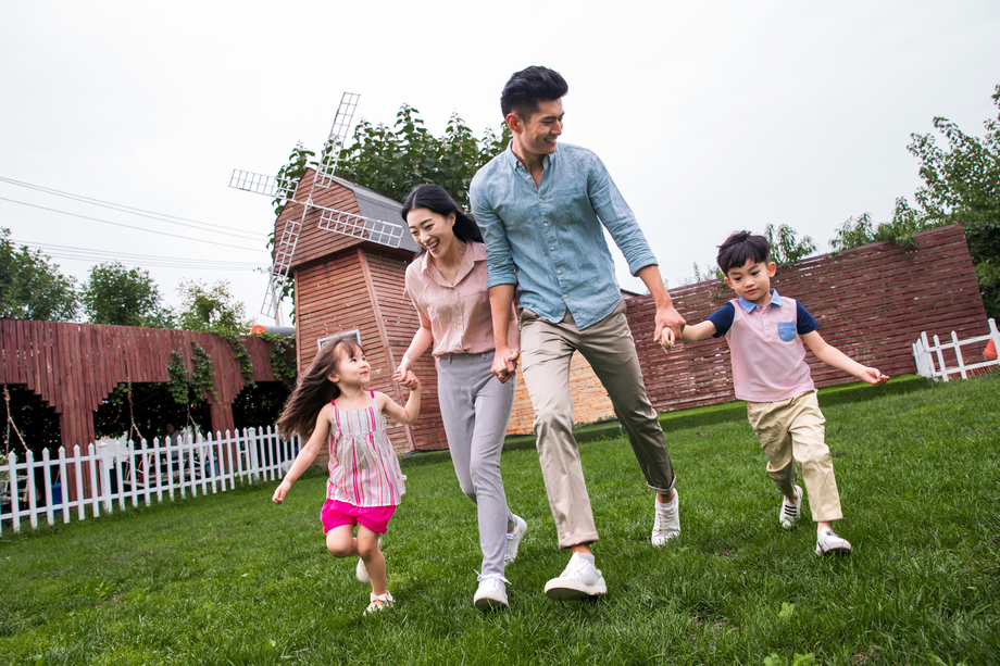 快乐四口之家在草地上奔跑