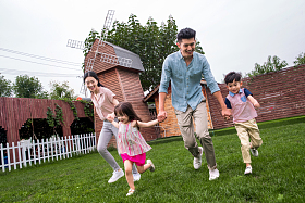 快乐四口之家在草地上奔跑