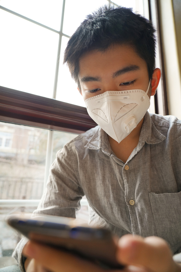 戴口罩的男孩看手机图片