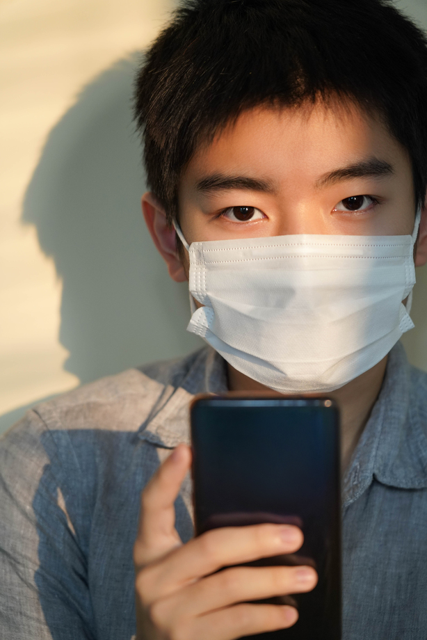戴口罩的男孩看手机图片