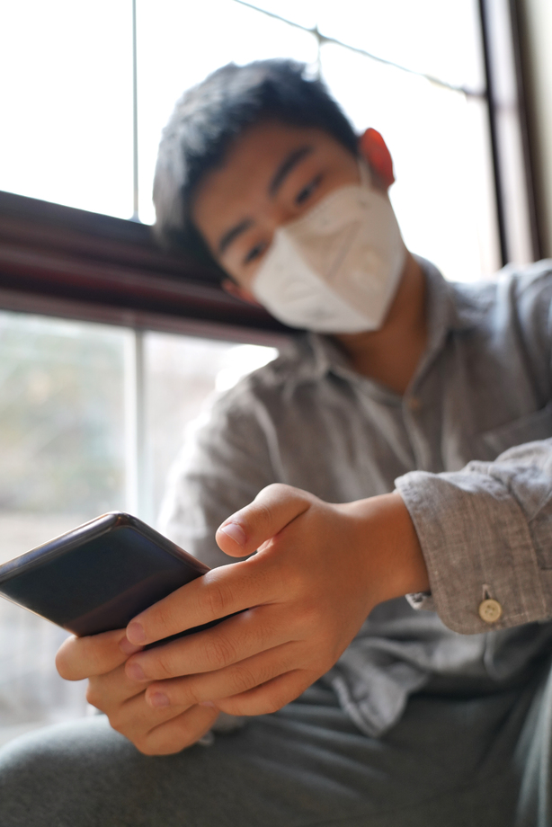 戴口罩的男孩看手机图片