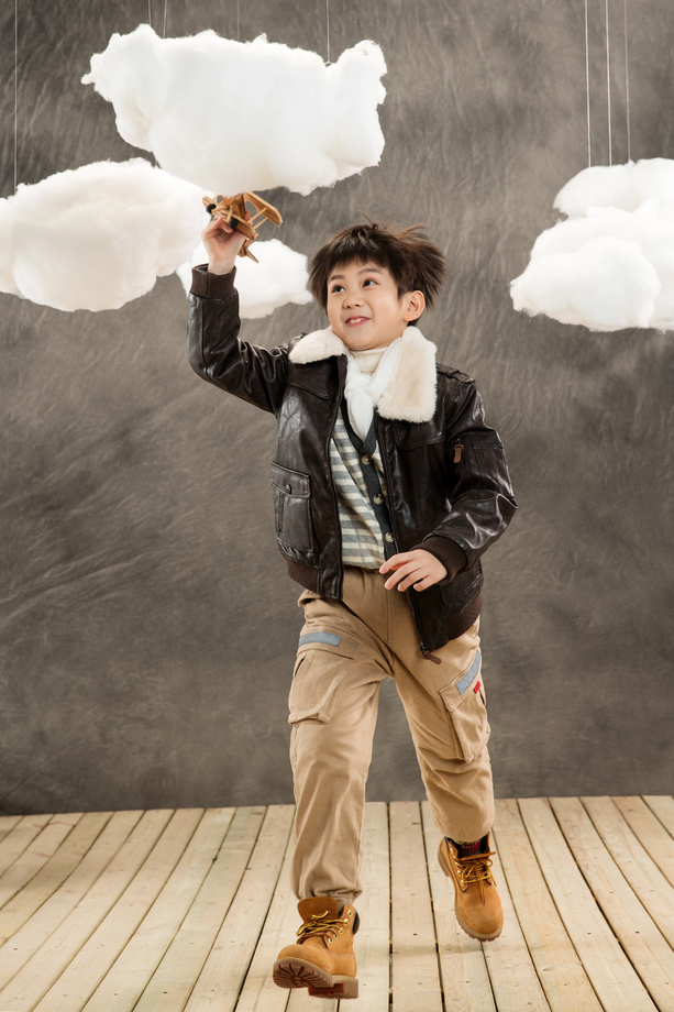 拿着飞机模型奔跑的男孩