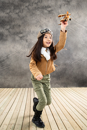 拿着飞机模型奔跑的女孩