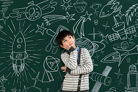 小男孩站在黑板前