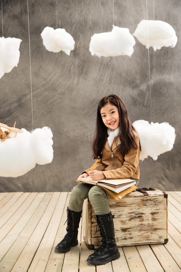 快乐女孩坐在行李箱上写日记 快乐女孩坐在行李箱上写日记