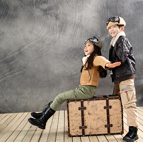 快乐的小飞行员坐在行李箱上一起玩耍