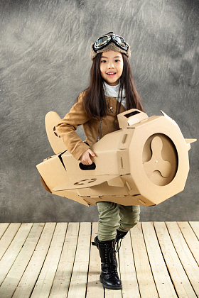 驾驶纸飞机的快乐女孩照片