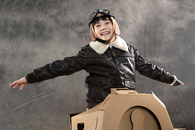 快乐儿童驾驶纸飞机照片