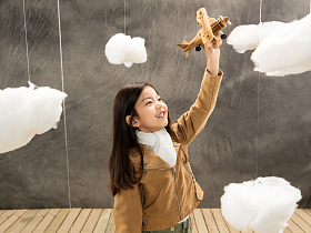 快乐女孩拿着飞机模型