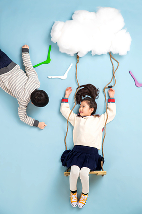 快乐儿童在云彩上荡秋千图片