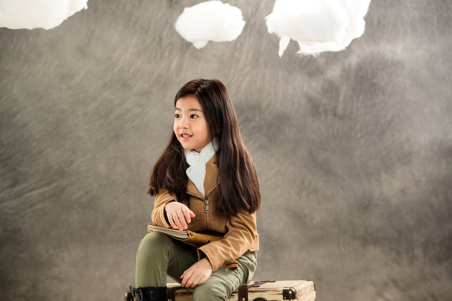 小女孩抱着笔记本坐在行李箱上 小女孩抱着笔记本坐在行李箱上