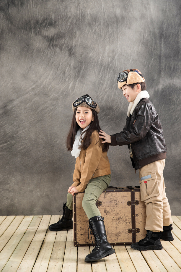 快乐的小飞行员坐在行李箱上一起玩耍