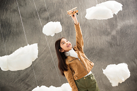 快乐女孩举着飞机模型