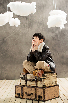 快乐男孩坐在行李箱上想象图片