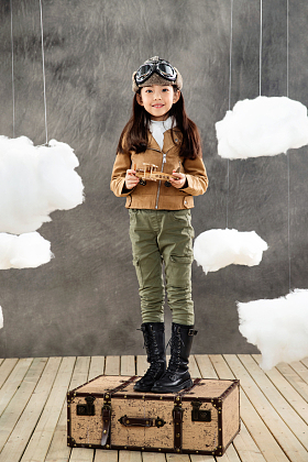 站在行李箱上的女孩拿着飞机模型