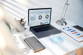 书桌上的笔记本电脑和一次性口罩