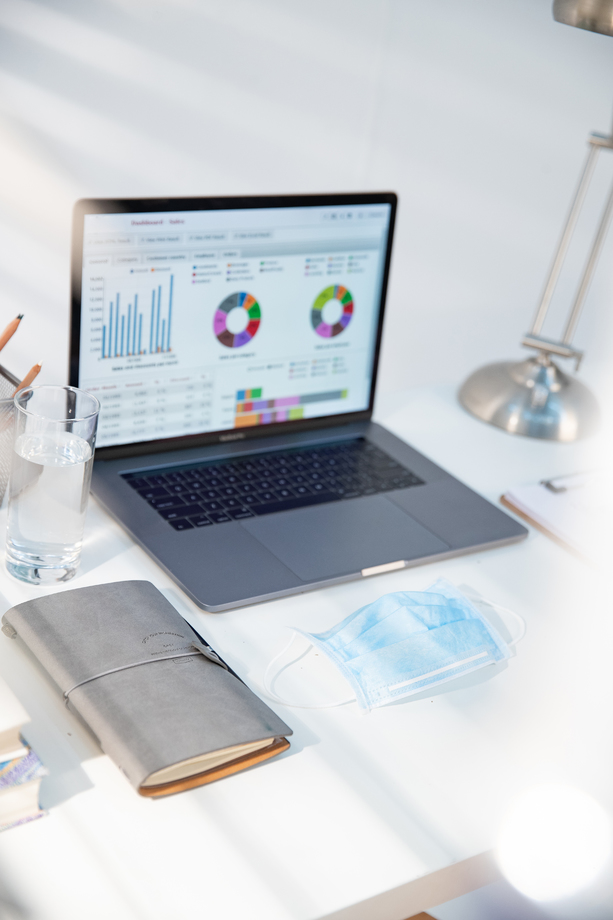 书桌上的笔记本电脑和一次性口罩 书桌上的笔记本电脑和一次性口罩