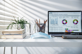 书桌上的电脑和一次性口罩图片