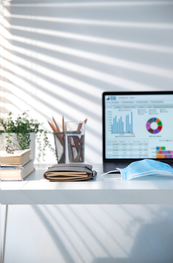 书桌上的电脑和一次性口罩照片