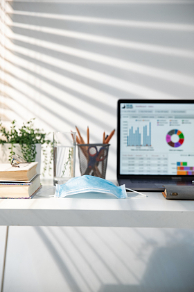 书桌上的电脑和一次性口罩图片