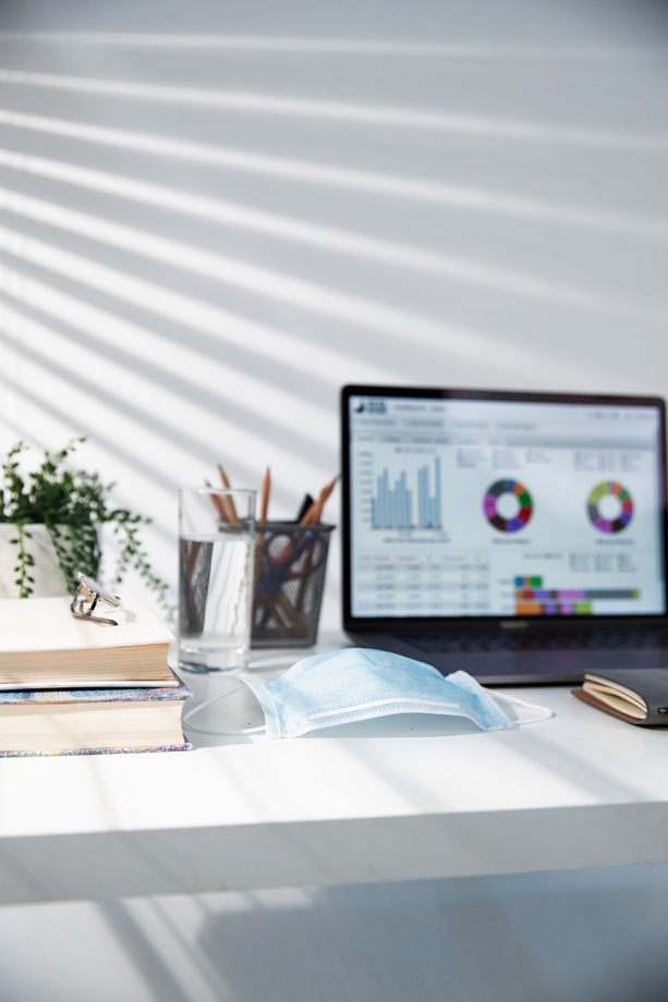 书桌上的电脑和一次性口罩图片