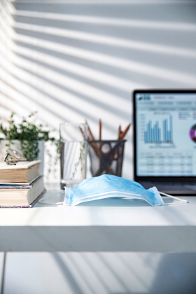 书桌上的电脑和一次性口罩图片