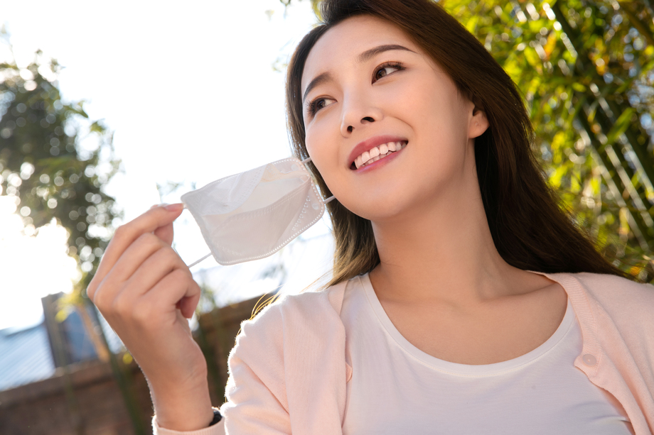 在户外摘下口罩的青年女人图片