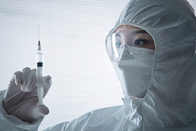 穿防护服的医生拿着注射器图片