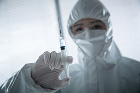 穿防护服的医生拿着注射器图片