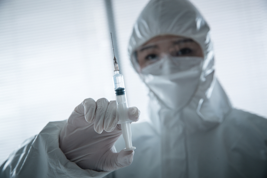 穿防护服的医生拿着注射器图片