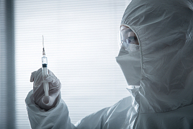 穿防护服的医生拿着注射器