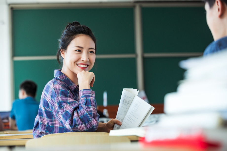 教室里回头讨论学习的大学生图片