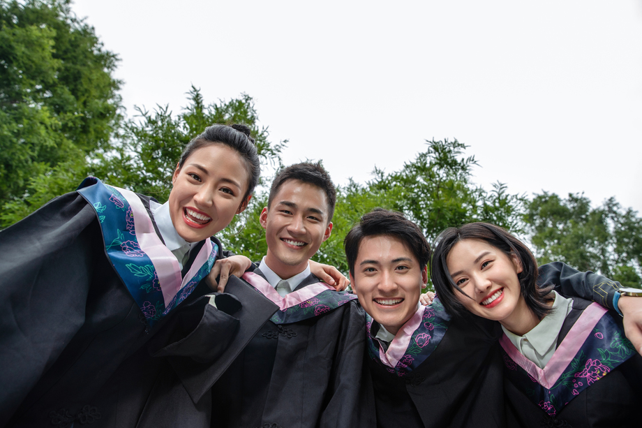 户外穿着学士服的大学生搂在一起 户外穿着学士服的大学生搂在一起