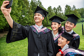 四个身穿学士服的大学生一起自拍