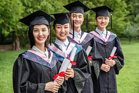 户外穿着学士服的大学生站成一排