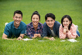 快乐的大学生趴在草地上