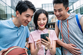 快乐的大学生在户外看手机图片