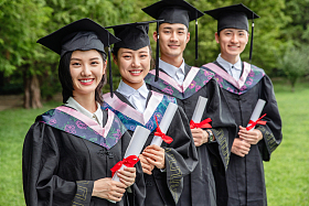 户外四个穿着学士服的大学生站一排