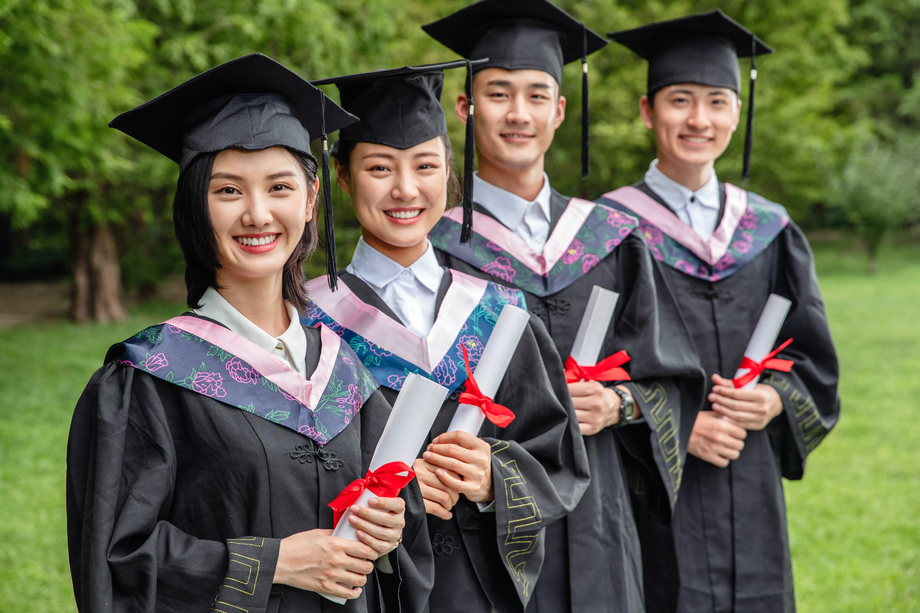 户外四个穿着学士服的大学生站一排