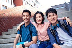 快乐的大学生坐在户外的楼梯上