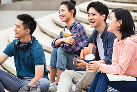 年轻的大学生坐在台阶上弹吉他