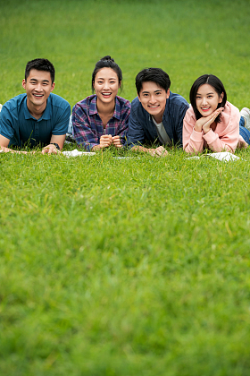 快乐的大学生趴在草地上