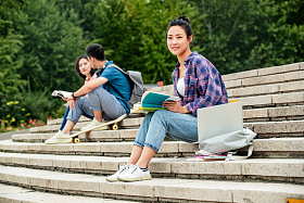 快乐的大学生坐在台阶上学习