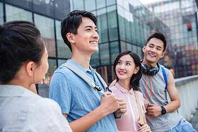 户外四个大学生一起靠在护栏上闲聊