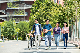 阳光下快乐的大学生在校园里步