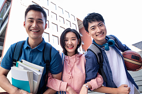 校园里快乐的三个大学生挽在一起