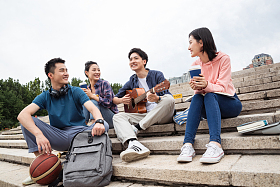 年轻的大学生坐在台阶上闲聊