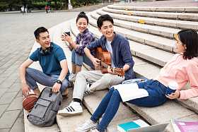 年轻的大学生坐在台阶上闲聊