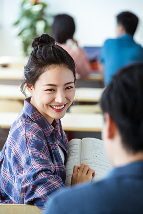 教室里回头讨论学习的大学生图片