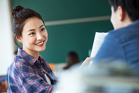 教室里回头讨论学习的大学生图片